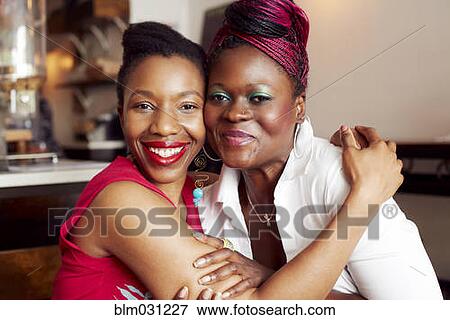 Stock Photo - Women hugging in cafe. Fotosearch