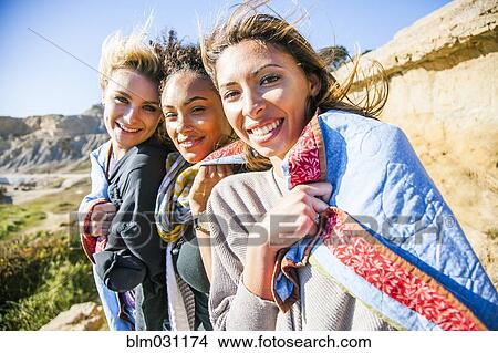 Picture - Women wrapped in blanket on rural hillside. Fotosearch