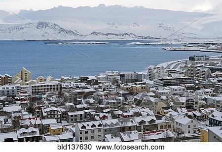Stock Image - Aerial view of snowy city in rural landscape. Fotosearch