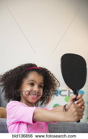 Stock Photograph - African American girl admiring herself in mirror. Fotosearch