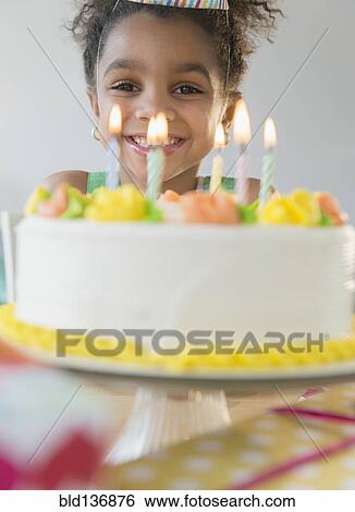 Stock Photograph - African American girl celebrating birthday. Fotosearch