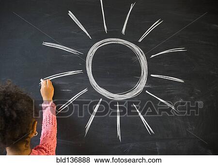 Stock Photo - African American girl drawing sun on board in classroom. Fotosearch