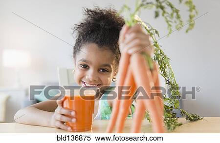 Stock Photography - African American girl drinking carrot juice. Fotosearch