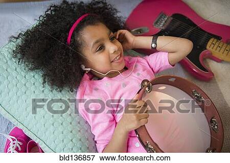 African American girl listening to music holding tambourine View Large Photo Image Stock Photo - African American girl listening to music holding tambourine. Fotosearch