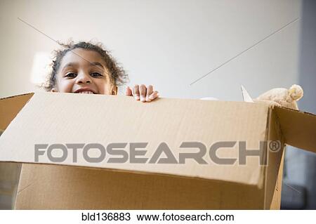 Stock Image - African American girl playing in cardboard box. Fotosearch