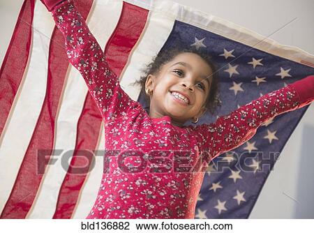 Stock Image - African American girl playing with United States flag. Fotosearch