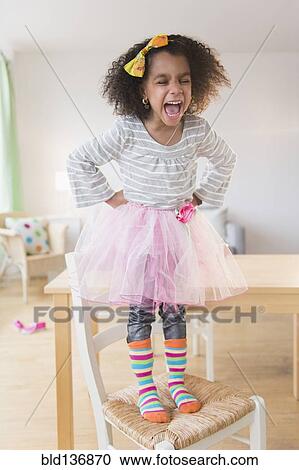 African American girl shouting on chair View Large Photo Image Stock Image - African American girl shouting on chair. Fotosearch