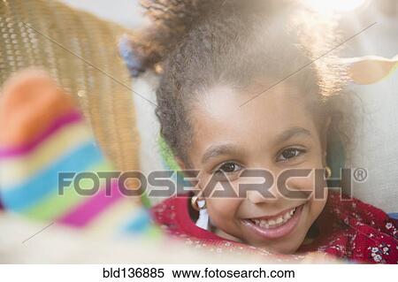 Stock Photography - African American girl smiling in basket. Fotosearch
