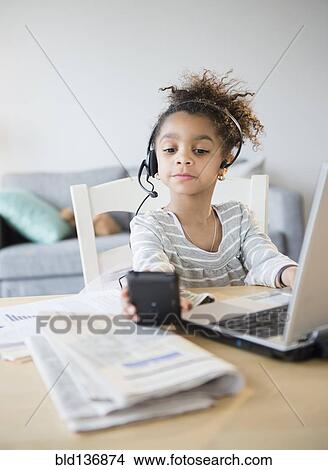 Picture - African American girl using headset, cell phone and laptop. Fotosearch