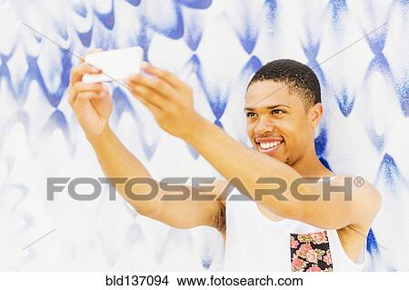 African American man taking cell phone pictures View Large Photo Image Picture - African American man taking cell phone pictures. Fotosearch