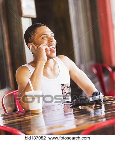 African American man talking on cell phone at cafe View Large Photo Image Stock Image - African American man talking on cell phone at cafe. Fotosearch