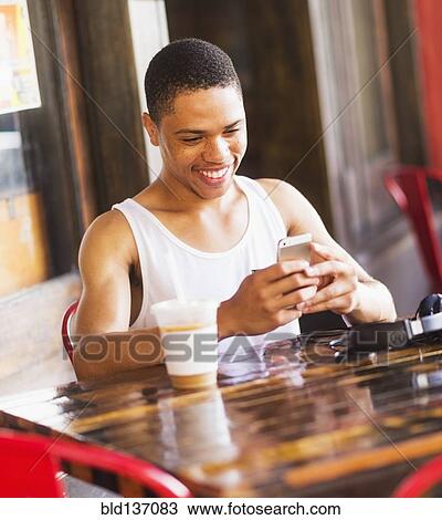 African American man using cell phone at cafe View Large Photo Image Stock Image - African American man using cell phone at cafe. Fotosearch