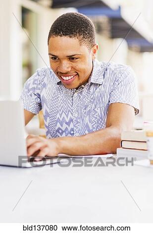 African American man using laptop at sidewalk cafe View Large Photo Image Stock Image - African American man using laptop at sidewalk cafe. Fotosearch
