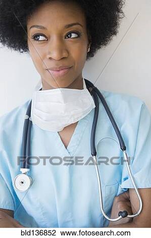 Stock Image - African American nurse wearing stethoscope and surgical mask. Fotosearch