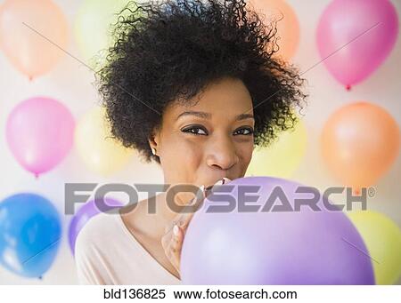 African American woman blowing up balloon for party View Large Photo Image Stock Photography - African American woman blowing up balloon for party. Fotosearch