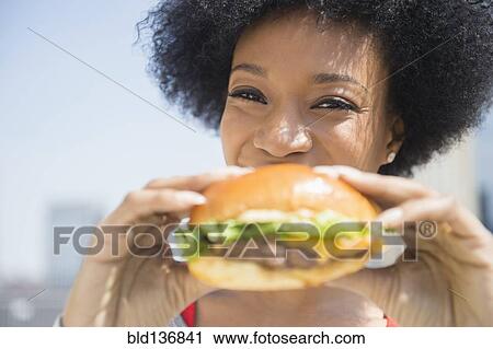 African American woman eating cheeseburger View Large Photo Image Stock Image - African American woman eating cheeseburger. Fotosearch