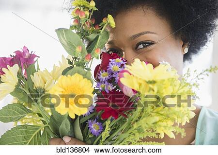 Picture - African American woman holding bouquet of flowers. Fotosearch