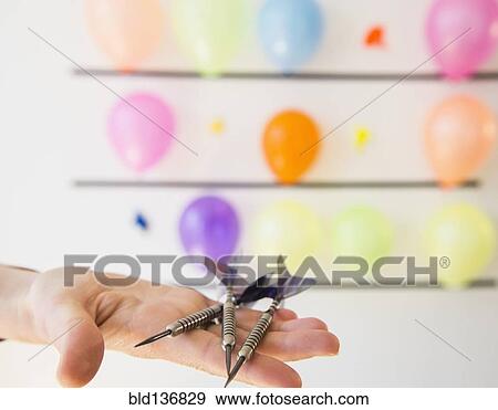 African American woman holding darts by wall of balloons View Large Photo Image Stock Photo - African American woman holding darts by wall of balloons. Fotosearch