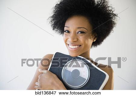 African American woman holding scale View Large Photo Image Stock Photo - African American woman holding scale. Fotosearch