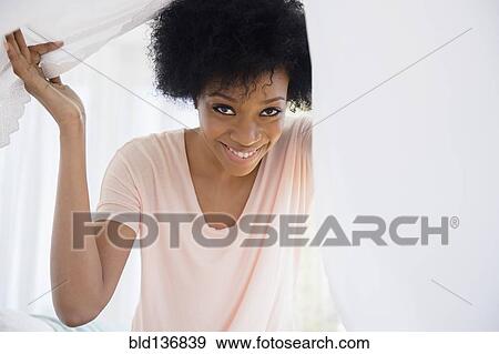 Stock Photo - African American woman playing with blanket. Fotosearch