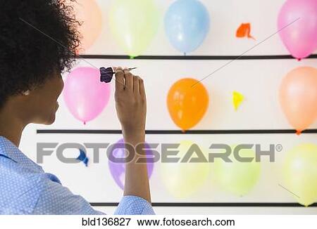 African American woman popping balloons with dart View Large Photo Image Stock Photo - African American woman popping balloons with dart. Fotosearch