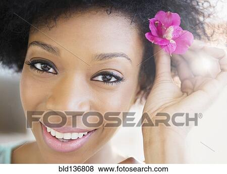 Stock Photo - African American woman wearing flower in hair. Fotosearch