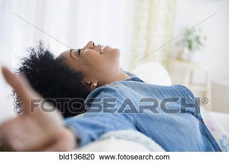 African American woman with arms outstretched on sofa View Large Photo Image Stock Image - African American woman with arms outstretched on sofa. Fotosearch