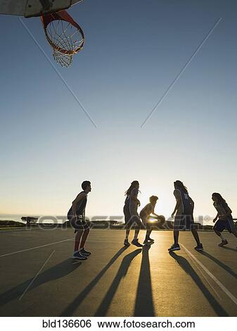 Back lit basketball teams playing on court View Large Photo Image Stock Photograph - Back lit basketball teams playing on court. Fotosearch