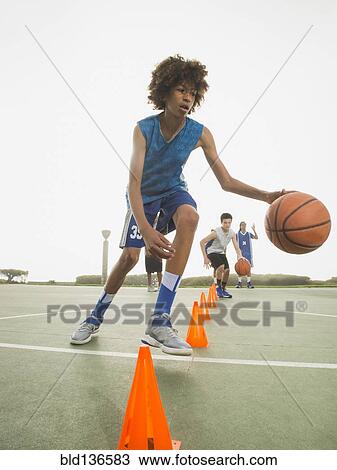 Stock Image - Basketball team doing drills at practice. Fotosearch