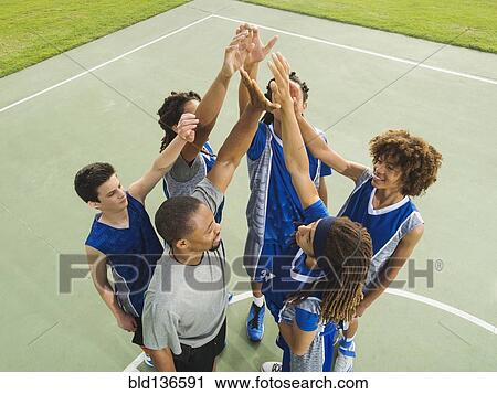 Stock Image - Basketball team high fiving on court. Fotosearch