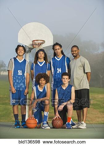 Stock Photo - Basketball team posing on court. Fotosearch