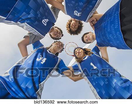 Stock Image - Basketball team smiling on court. Fotosearch
