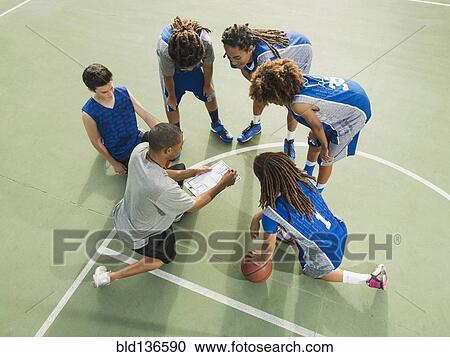 Stock Image - Basketball team talking on court. Fotosearch