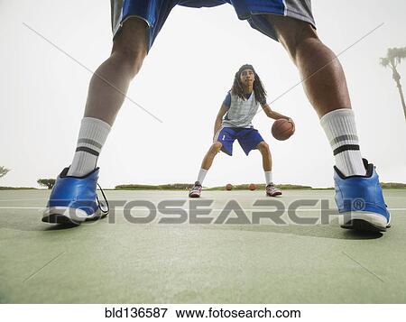 Stock Photo - Basketball teams playing on court. Fotosearch