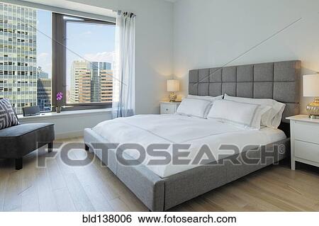 Bed and armchair in bedroom overlooking city skyscraper View Large Photo Image Stock Photograph - Bed and armchair in bedroom overlooking city skyscraper. Fotosearch