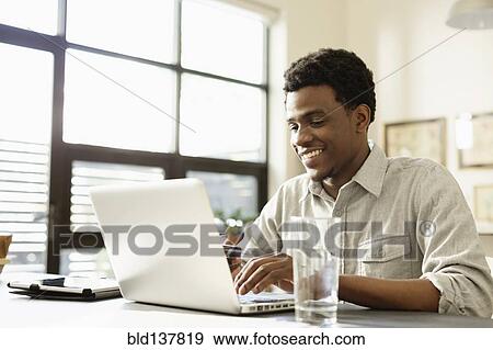 Black businessman working at desk View Large Photo Image Stock Photo - Black businessman working at desk. Fotosearch