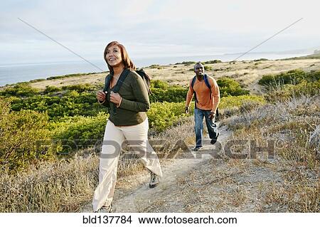 Picture - Black couple hiking on rural path. Fotosearch