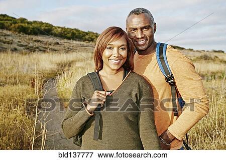 Stock Photo - Black couple hiking on rural path. Fotosearch