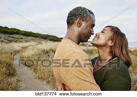 Picture - Black couple hugging on rural path. Fotosearch