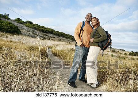 Stock Photography - Black couple hugging on rural path. Fotosearch