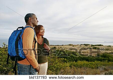 Stock Image - Black couple overlooking rural hillside. Fotosearch