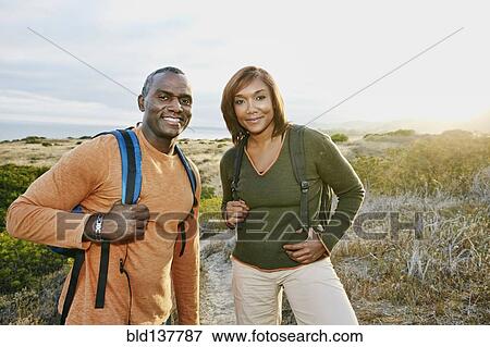 Stock Photo - Black couple smiling on rural hillside. Fotosearch