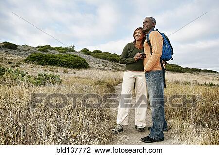 Stock Image - Black couple standing on rural path. Fotosearch