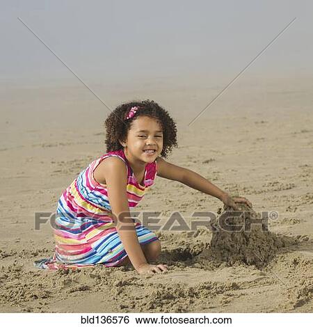 Black girl building sand castle on beach View Large Photo Image Stock Photograph - Black girl building sand castle on beach. Fotosearch