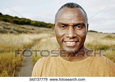 Stock Photo - Black man standing on rural path. Fotosearch