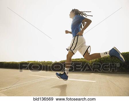 Black teenage boy running on street View Large Photo Image Stock Photo - Black teenage boy running on street. Fotosearch