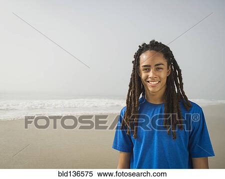 Black teenage boy smiling on beach View Large Photo Image Stock Photography - Black teenage boy smiling on beach. Fotosearch