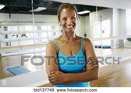 Stock Photo - Black woman smiling in yoga studio. Fotosearch