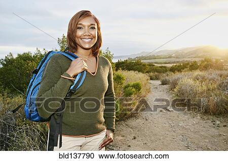 Stock Image - Black woman smiling on rural hillside. Fotosearch