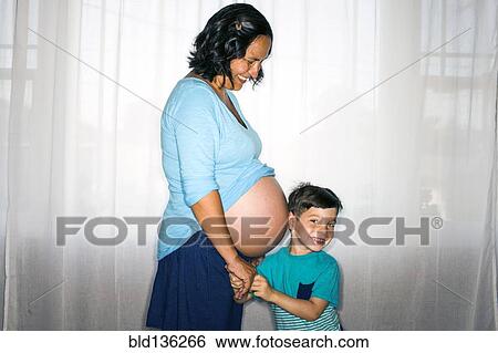 Stock Photograph - Boy listening to mother's pregnant belly. Fotosearch